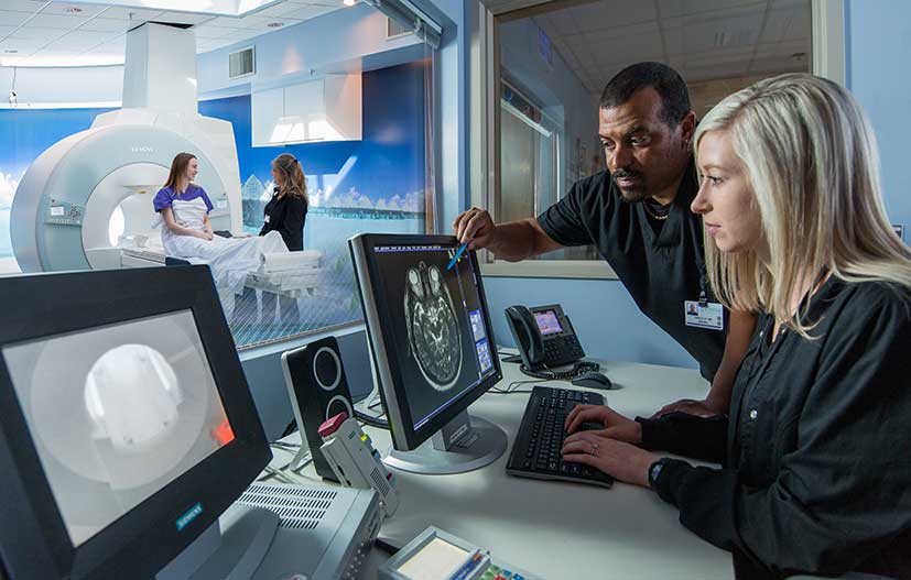 MRI technician talks with patient before procedure.