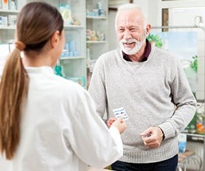 Picture of pharmacists talking with male customer about medications