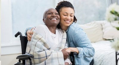 Woman hugging mom in wheelchair