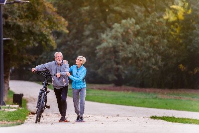 Couple walking in a park, pushing a bike