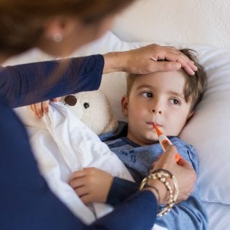 Boy in bed with thermometer