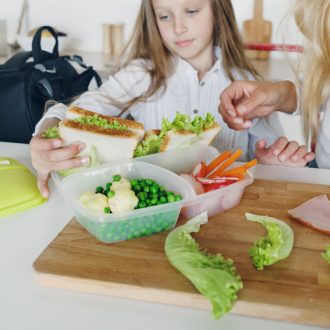 Child packs sack lunch.