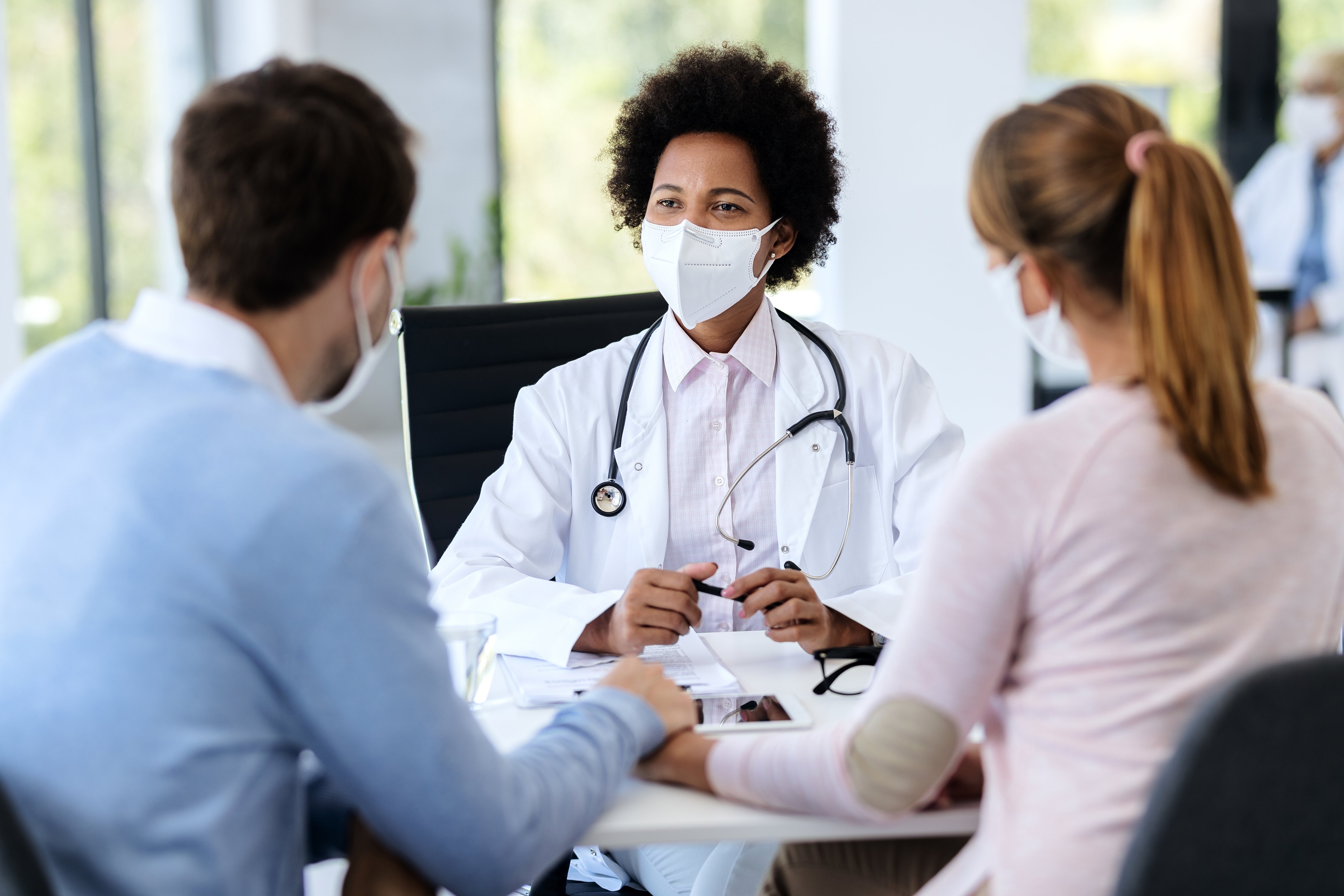 Couple sitting at a table with a Doctor