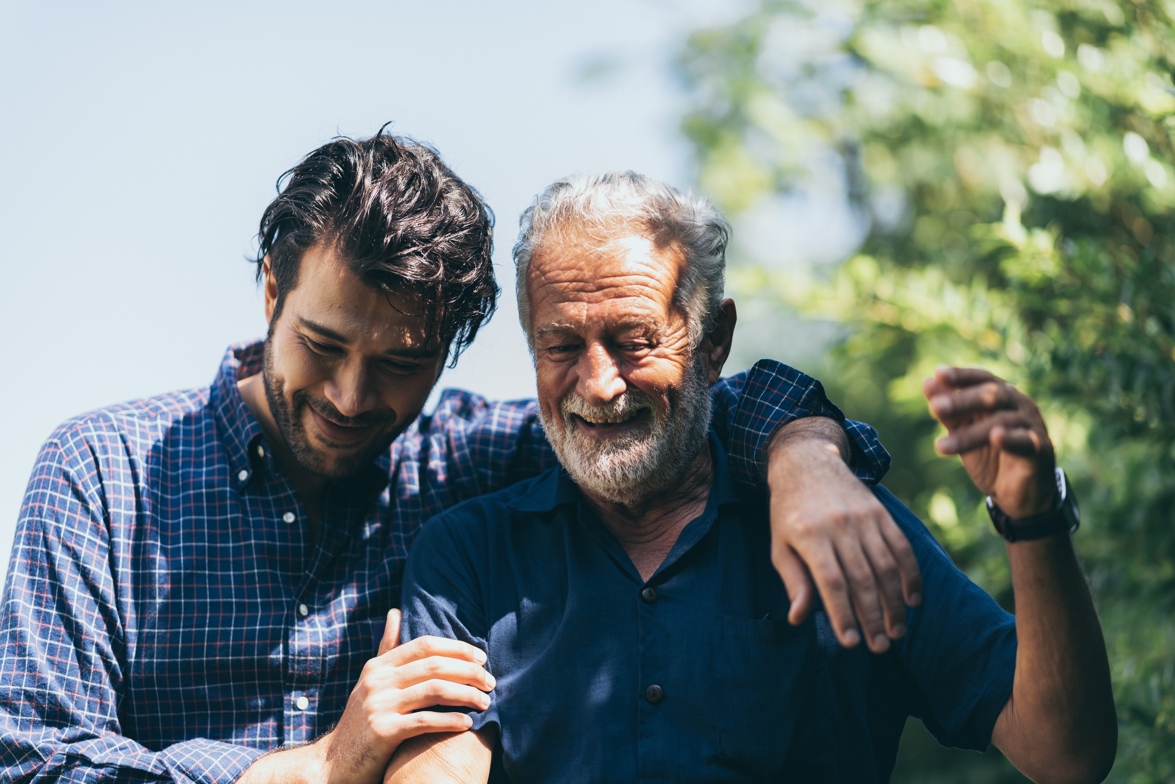 Son and father with arms over shoulders