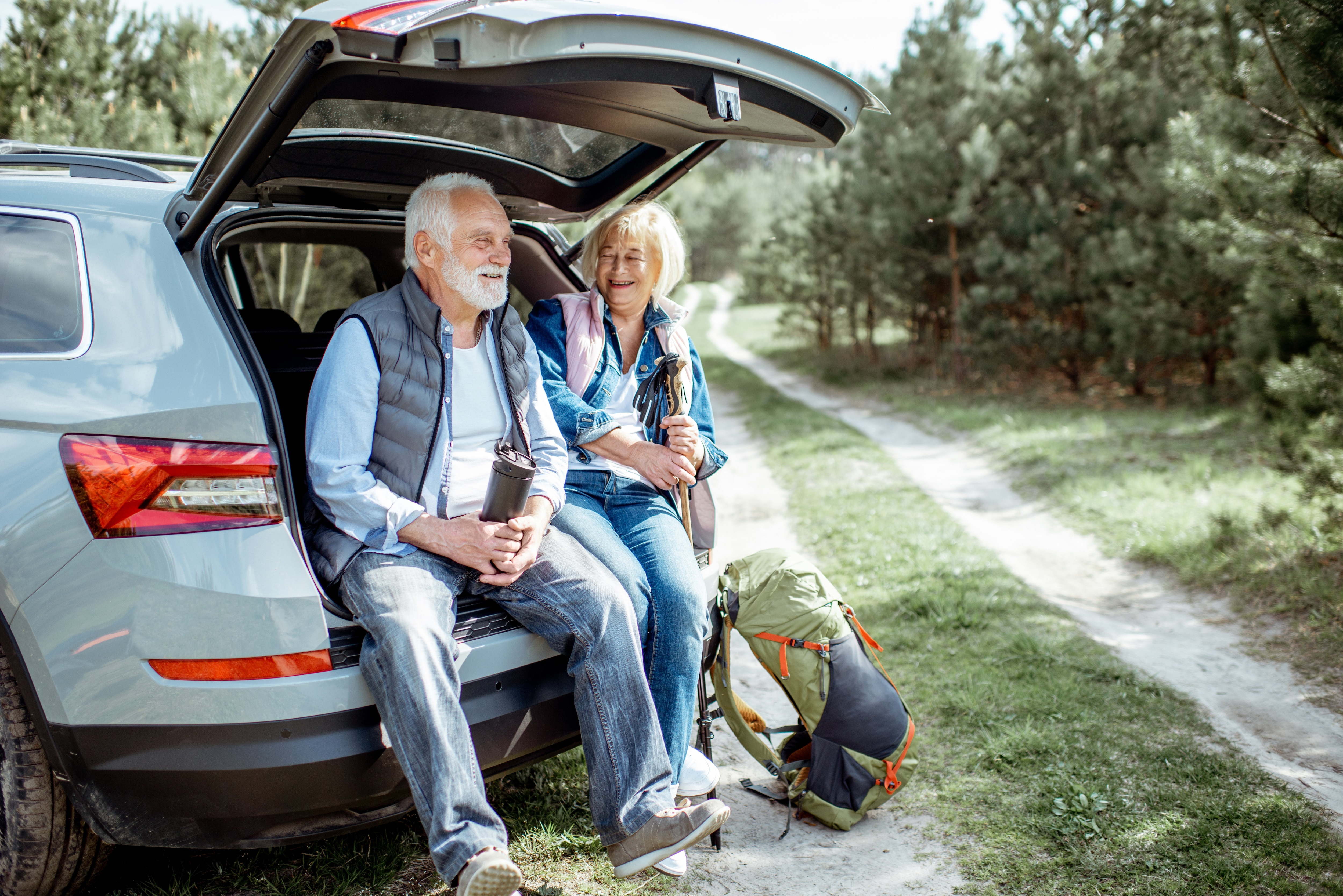 Man and Woman sitting on the tailgate of an SUV