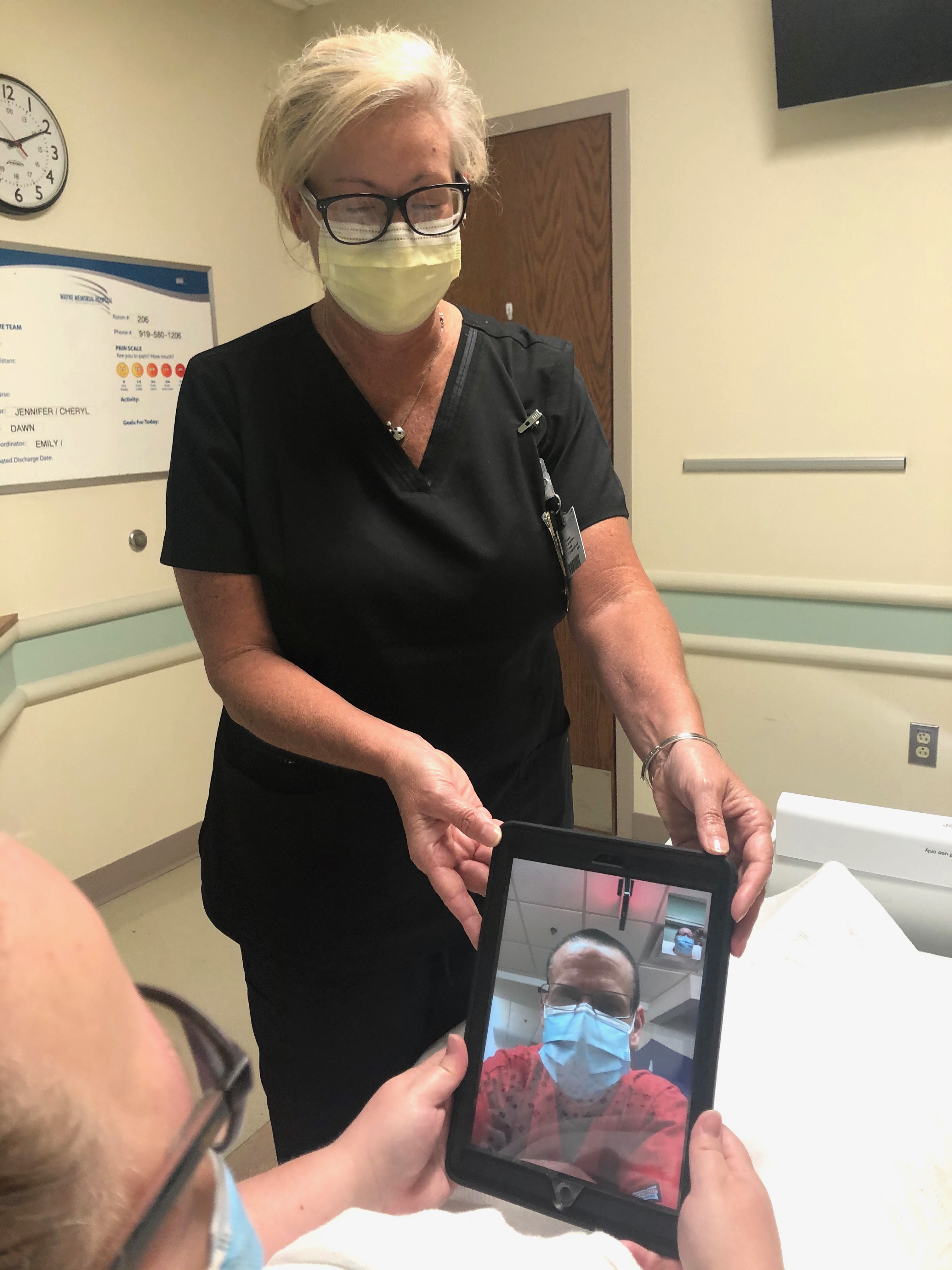 Wayne UNC staff help patient video chat with a loved one